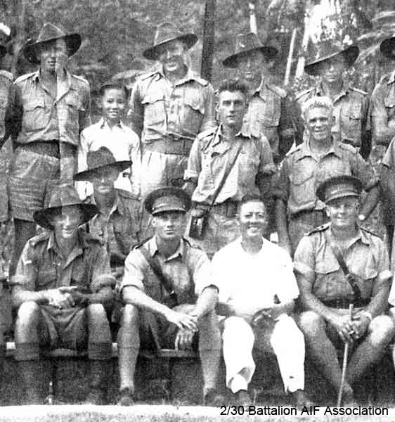Funeral, Malacca - Part 2
While the Battalion was at Batu Pahat,  L/Sgt. Kenneth Lindsay, became the first casualty in Malaya. He was badly injured while playing football, and died on 10/11/1941.

He was given a full military funeral and buried in the A.I.F. cemetery at Malacca. His grave was later transferred to the Kranji Cemetery in Singapore.

NX45773 - LINDSAY, Kenneth William (Ken), L/Sgt. - D Company, Ord. Room

Left to right:

Back row:
1) ?
2) NX47590 - RICHES, Frederick Holmes (Harry), A/U/Cpl. - HQ Company, Transport Platoon
3) ?
4) ?

Middle row (standing):
1) ?
2) NX26575 - KELEHER, John Samuel (Ned), Pte. - HQ Company, A/A Platoon
3) NX54474 - STEVENS, Francis Rupert Brotherson (Snowy), Pte. - HQ Company, Mortar Platoon

Middle row (seated):
1) NX37456 - McNAMARA, William Patrick (Bill), Pte. - B Company, 10 Platoon

Front row:
1) NX31064 - AMBROSE, Richard Robert James (Jimmy or Bluey), Cpl. - B Company, 12 Platoon
2) NX12530 - COOPER, James Herbert (Jim), Lt. - HQ Company, Carrier 2 I/c
3) ?
4) NX34711 - MELVILLE, William Sydney (Billy (The Pig)), Lt. Col. - D Company, O/C D Coy. 

