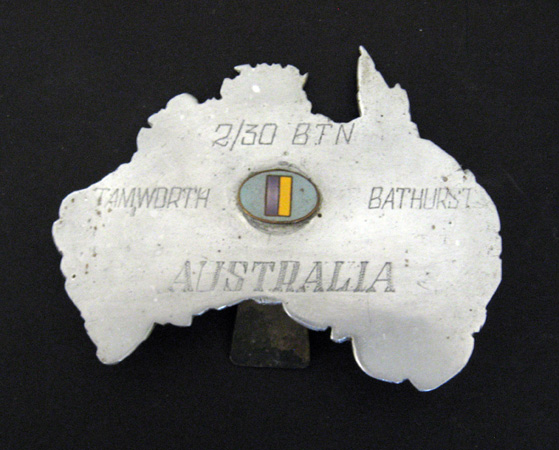 Map of Australia
Outline map of mainland Australia cut from a piece of aluminium. A small enamalled 2/30 Bn. colour patch is attached to the middle of the map. 

The following words have been hand engraved onto the map:
2/30 BTN
TAMWORTH
BATHURST
AUSTRALIA

Formerly owned by:
NX46929 - MIDDLETON, William (Bill), A/U/Sgt. - BHQ. Band

Overall dimensions:
Width: 105mm, Height: 82mm. 

Keywords: 20131125a