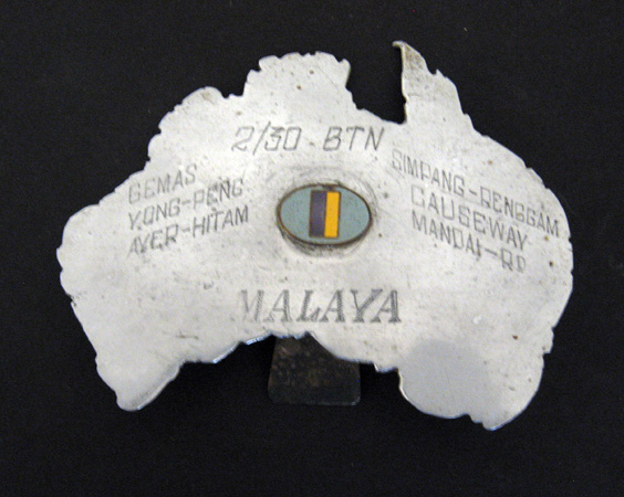 Map of Australia
Outline map of mainland Australia cut from a piece of aluminium. A small enamalled 2/30 Bn. colour patch is attached to the middle of the map. 

The following words have been hand engraved onto the map:
2/30 BTN
GEMAS YONG-PENG AYER-HITAM
SIMPANG-RENGGAM CAUSEWAY MANDAI-RD
MALAYA

Formerly owned by:
NX46929 - MIDDLETON, William (Bill), A/U/Sgt. - BHQ. Band

Overall dimensions:
Width: 105mm, Height: 82mm. 

Keywords: 20131125a