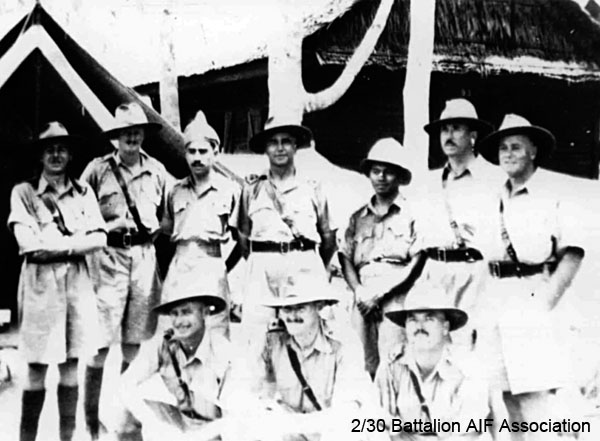 Kluang Aerodrome, November 1941
Group of Officers, with 2 Indian Officers at Kluang Aerodrome exercise in defence, November 1941

Left to right:
Back row:
1) NX70435 - ANDERSON, Roderic Henry, Maj. - A Coy. O/C A Coy. MiD ED.
2) NX70426 - MACAULEY, Norman Gilmour (Red), Capt. - HQ Coy. O/C Tpt. Pl. MBE Staff Capt. 27 Bde
3) Unknown
4) NX70416 - GALLEGHAN (Sir), Frederick Gallagher (Black Jack), Brig. - BHQ. CO. 2/30 Bn. D.S.O., O.B.E., I.S.O., E.D., K.B.
5) Unknown
6) NX34792 - DUFFY, Desmond Jack (Mum), Col. - B Coy. O/C B Coy. MC ED.
7) NX34711 - MELVILLE, William Sydney (Billy (The Pig)), Lt. Col. - D Coy. O/C D Coy. WiA Gemas, MiD Repatriated 10/2/1942

Front row:
1) NX34738 - LAMACRAFT, Alfred Howard Maudslay, Capt. - C Coy. O/C C Coy. E.D.
2) NX76207 - PEACH, Francis Stuart Banner (Stuart), Col. - BHQ. Adjt. MiD OBE. 1963. ED, ToS 28/7/1941
3) NX70427 - JOHNSTON, Noel McGuffie (Charlie Chan), Lt. Col. - BHQ Coy. 2 I/c Bn. Pl. MiD ED.
