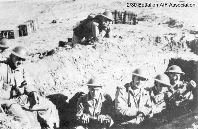 First firing of the Mortar
First firing of the new 3" mortar at Bathurst after first having Stokes mortar.

Left to right:
1) NX27259 - BLADWELL, Frederick Joseph (Fred), Sgt. - HQ Company, Mortar Platoon (seated with telephone)
2) NX32900 - SMITH, Reginald (Butch), Pte. - HQ Company, Mortar Platoon
3) NX32306 - MACIVER, Donald Gunn (Bluey), Cpl. - HQ Company, Mortar Platoon
4) NX41145 - LOVE, Sydney George (Sid), Pte. - HQ Company, Mortar Platoon
5) NX58187 - BARNS, Victor (Vic), L/Sgt. - HQ Company, Mortar Platoon (in rear of the mortar pit)
6) NX50446 - WALSHE, James Prior (Splinter or Jim), Pte. - HQ Company, Mortar Platoon
7) NX58157 - GREENWOOD, Frederick John (Jack), Pte. - HQ Company, Mortar Platoon
