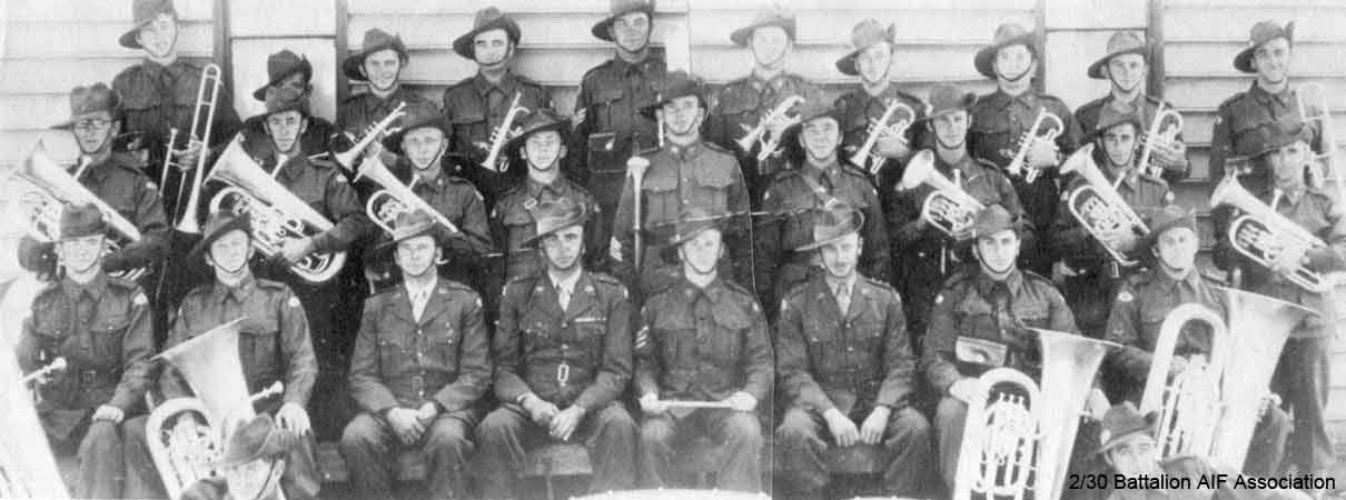2/30 Battalion Band
At Bathurst is 1941.

Left to right:

Back row:
1) NX68238 - DESMET, Stanley Joseph (Bill), Pte. - Trombone - "F" Force
2) NX68235 - COPLEY, Francis Peter, Pte. - Solo Cornet - "F" Force
3) NX68236 - LUGTON, Stanley James (Stan), Cpl. - Solo Cornet - "F" Force
4) NX36270 - ELPHICK, James Jack (Jack), Pte. - Solo Cornet - "F" Force
5) NX67631 - WATTERSON, Rowland Hubert (Roly), Sgt. - G Trombone - Died Kanburi No. 1 10/12/1943
6) NX36324 - BROUFF, Charles William (Charlie), Pte. - Cornet - "F" Force
7) NX66840 - WILKINSON, Dudley Norman, Pte. Cornet or Tenor Horn - "A" Force
8) NX68237 - HODGE, William Peter (Bill), Pte. - Cornet - "F" Force
9) NX68186 - HODGES, Alfred William James, Pte. - Cornet - Died Kami Sonkurai 16/10/1943 - "F" Force
10) ? - McLEOD, J., Pte. - Trombone

Middle row:
1) NX46929 - MIDDLETON, William (Bill), Cpl. - Eupho - Leader of Concert Party Orchestra, Changi
2) NX36142 - PARSONS, Lindsay Heyhoe, L/Cpl. - Eupho - Did not sail from Bathurst
3) NX57915 - VOLLHEIM, Eric Charles Norman, Pte. - Tenor Horn - "B" Force
4) NX53156 - BROWNBILL, Ronald Will Leonard (Bill), Pte. - Horn - Died at Tamarkan, 12/1/1944 - "A" Force
5) NX36443 - RINGWOOD, Stanley, Sgt. - Drum Major
6) NX36719 - MONTGOMERY, James William (Jim), Pte. - Side Drums - "F" Force
7) NX36267 - WHITTERON, Edward Sprowell (Ed), Pte. - Horn - Died Kuie 10/6/1943 - "F" Force
8) NX41078 - CROSSMAN, Alan Byron, Pte. - Baritone - Died at Kami Sonkurai, 16/10/1943 - "F" Force
9) NX35482 - MOUNTFORD, Laurence Gordon (Laurie), L/Cpl - Baritone - "J" Force

Front row:
1) NX69851 - RYAN, Patrick Leonard (Len), Pte. - B. B. Bass - "F" Force
2) NX36839 - EDMONDSTONE, Bertie Joseph (Bert), Pte. - B. B. Bass - Died at Shimo Sonkurai 29/8/1943 - "F" Force
3) NX34999 - RAMSAY, George Ernest, Major (Second in Command)
4) NX70416 - GALLEGHAN, Frederick (Black Jack) Gallagher, Lieutenant Colonel (Commanding Officer)
5) NX66171 - PALMER, Sidney John, Sgt - Bandmaster, Conductor & Solo Cornet - "B" Force
6) NX34738 - LAMACRAFT, Alfred Maudslay (Alf), Captain (Adjutant)
7) NX68232 - TEMPLEMAN, John James (Ben), Pte. - E Bass - "A" Force
8) NX68185 - BOWDEN, Thomas Arthur (Tom), Pte. - E Bass - "F" Force

Reclining:
1) NX36271 - GOUGH, William George (Bill), Pte. - Bass Drum - "A" Force
2) NX36098 - HART, James (Shorty), Pte. - Side Drum - "F" Force

Other Band members:
1) NX46241 - BARRETT, Victor Leslie, Pte. - "F" Force
2) NX72156 - JORDAN, Sydney Alfred Arthur, Pte. - Cornet - "F" Force
3) NX72160 - JORDAN, Walter Leo George, Pte. - Trombone
4) NX47007 - ROBINSON, Howard Charles (Bill), Pte. - Cornet - "A" Force
Keywords: Makan196 Makan242 Makan267