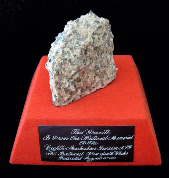 Souvenir of 8th Div. Memorial
Piece of granite from 8th Div. Memorial at Bathurst, mounted on a square red felt covered base, with engraved label. Gift from 'Black Jack' Galleghan to Maj. Allan Shearing.

Inscription reads:
This granite is from the National Memorial to the Eighth Australian Division A.I.F. at Bathurst New South Wales Dedicated August 15th 1970

NX70416 - GALLEGHAN (Sir), Frederick Gallagher (Black Jack), Brig. - BHQ. CO. 2/30 Bn. D.S.O., O.B.E., I.S.O., E.D., K.B.

Overall dimensions:
Width: 128mm, Depth: 128mm, Height: 100mm. 
Keywords: 20131125b