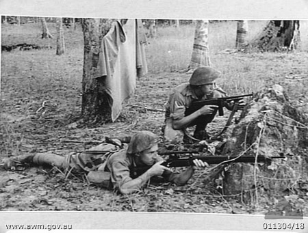 NX51313 - Ross MADDEN and NX26692 - Curly BLOMFIELD
Australian War Memorial caption reads:
1942-01, MALAYA. PRIVATE J. R. MADDEN, AN AIF SNIPER, AND LANCE CORPORAL BLOMFIELD WITH A THOMPSON SUBMACHINE GUN ON THE LOOK OUT FOR ENEMY TROOPS IN A RUBBER PLANTATION.

Left to right:
1) NX51313 - MADDEN, James Ross Harrington (Ross), Pte. - A Company, 8 Platoon
2) NX26692 - BLOMFIELD, Alfred Lindsay (Curly), L/Cpl. - A Company, 8 Platoon. Wounded in Action at Gemas
Keywords: 100105c