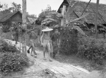 Kuching POW Camp
Australian War Memorial caption reads:
KUCHING, SARAWAK, BORNEO. 1945-09-12. THREE 8TH DIVISION OFFICERS, EX PRISONERS OF WAR OF THE JAPANESE, CARRY THEIR LUGGAGE THROUGH THE OFFICERS' QUARTERS OF THE KUCHING POW AND INTERNMENT CAMP ON THEIR WAY TO BOARD THE HOSPITAL SHIP WANGANELLA. LEFT TO RIGHT: LIEUTENANT (LT) JOHN EDEN, 2/18TH BATTALION; CAPTAIN R. H. "POM" BROWN, IN COOLIE HAT, 2/10TH FIELD REGIMENT; LT RON OLLIS, 2/30TH BATTALION.

Left to right:
1) NX45910 - EDEN, John, Lt. - 2/18 Bn.
2) QX6384 - BROWN, R.H. (Pom), Capt. - 2/10 Field Regiment (in coolie hat)
3) NX70446 - OLLIS, Ronald Nesbitt (Ron), Lt. - D Company, O/C 17 Platoon.
Keywords: 100105c