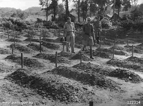 Graves at Khai Sai Yok, Thailand
Khai Sai Yok, Thailand. 20 October 1945. Dutch and Australian officers moving through the Australian and British section of the cemetery, inspecting the conditions of the graves. Each grave is a mound of dirt marked by a small wooden cross.
