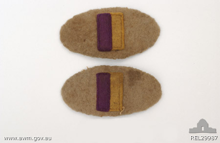 Pair of colour patches for 2/30 Battalion
Australian War Memorial caption reads:
Physical description: Felt; Pair of colour patches for 2/30 Battalion. Grey oval patch with a vertically aligned rectangle sewn in the centre. The rectangle is divided into purple and gold halves.

Summary: Associated with NX3971 G C Quinn who served with the 2/30 Battalion. Quinn was captured by the Japanese after the fall of Singapore and became a prisoner of war, first in Thailand and then in Japan. During his internment it was necessary to amputate one of his legs. He was possibly also known as Reginald George Quinton.

NX37544 - QUINTON, Reginald George, Pte. - BHQ. D&P Platoon.
Right leg amputated below knee, 7/7/1944; recovered from Japanese in Thailand on 20/8/1945; emplaned Singapore on 6/10/1945 for return to Australia; arrived Melbourne 8/10/1945; then by train to Sydney, arrived 9/10/1945
Keywords: 100105c