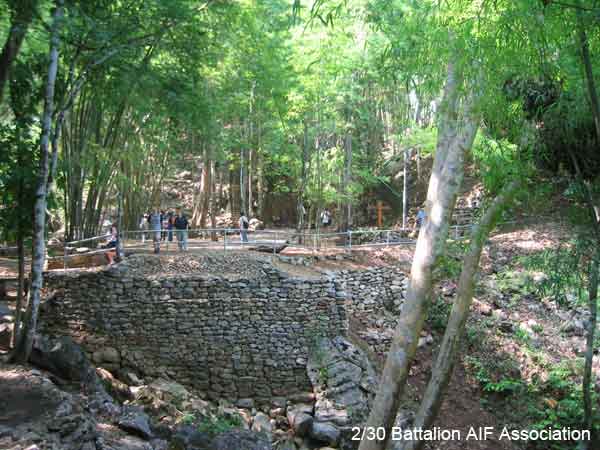 The remains of the rock and timber footings of a timber bridge on the Burma Thailand Railway. This bridge is located at the end of the cutting known as Hellfire Pass.

The Hellfire Pass memorial cross can be seen in the right middle of the photo.
