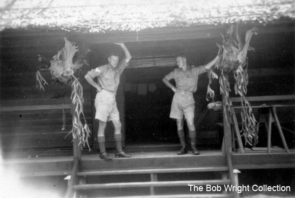 In camp at Batu Pahat
"Just me and Wally Graves holding up the roof and verandah. Oct. 1941."

Left to right:
1) NX36166 - WRIGHT, Robert, Cpl. - HQ Coy. Sig. Pl. 
2) NX37372 - GRAVES, Walter James, Pte. - HQ Coy. Sig. Pl. to 2/20 Bn 24/12/1941, MpD Singapore Island

1. The photographs are to be known as The Bob Wright Collection.
2. Reproduction of the Collection or any part of it is prohibited without written permission.
3. Permission is granted to the 2/30th Batallion Association to reproduce the Collection as it deems appropriate.
4. Permission is granted to the Australian War Memorial Museum to reproduce the Collection as it deems appropriate.
5. All other permission is specifically withheld.
6. Written application for permission to reproduce the Collection, or part of it, may be made to:
Mr I. Wright
95 Hewitt Avenue
Wahroonga 2076 New South Wales

